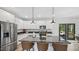 Bright kitchen with white cabinets, granite countertops, a central island with seating, and stainless steel appliances at 5550 Mountain Trl, Snow Camp, NC 27349