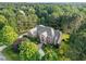 Beautiful aerial view of a brick house surrounded by mature trees and lush landscaping at 5768 Cavanaugh Dr, Raleigh, NC 27614