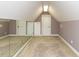 Finished attic space featuring neutral walls, carpet, storage cabinets, and a mirrored wall reflecting the spacious area at 5768 Cavanaugh Dr, Raleigh, NC 27614