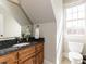 Bathroom with natural lighting, granite counters, and bright white toilet at 5768 Cavanaugh Dr, Raleigh, NC 27614
