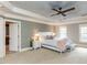 Spacious bedroom with ceiling fan and view to ensuite bathroom and windows at 5768 Cavanaugh Dr, Raleigh, NC 27614