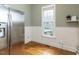 Light-filled breakfast nook with a large window, stainless steel refrigerator, and hardwood floors at 5768 Cavanaugh Dr, Raleigh, NC 27614