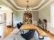 Elegant dining room with a wooden table, chandelier, and arched entryways at 5768 Cavanaugh Dr, Raleigh, NC 27614