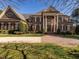 Majestic brick home featuring a grand entrance with columns, manicured lawn, and a brick driveway, perfect for luxury living at 5768 Cavanaugh Dr, Raleigh, NC 27614
