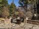 Cozy backyard fire pit area with stone patio, seating, and a stone wall at 5768 Cavanaugh Dr, Raleigh, NC 27614