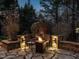Cozy backyard fire pit area with stone patio, seating, and landscape lighting for evening relaxation at 5768 Cavanaugh Dr, Raleigh, NC 27614