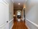 Hallway with hardwood floors, arched doorways, leading to other rooms with neutral paint at 5768 Cavanaugh Dr, Raleigh, NC 27614