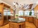 Open kitchen featuring stainless appliances, hardwood floors, custom cabinets, and a large island with granite counters at 5768 Cavanaugh Dr, Raleigh, NC 27614