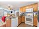 Traditional kitchen features wooden cabinets, white appliances and an island sink, and opens to the adjacent living area at 6 N Carolina Ave, Benson, NC 27504