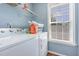 Laundry room with washer, dryer, shelf and a natural light-filled window at 6 N Carolina Ave, Benson, NC 27504