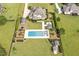 Complete aerial view of the backyard, featuring the pool, cabana, meticulous landscaping, and lush greenery at 6250 Moinear Ln, Chapel Hill, NC 27514