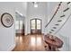 Bright foyer with dark wood floors, staircase, entry door, and soaring ceilings at 6250 Moinear Ln, Chapel Hill, NC 27514