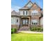 Stately home with a well-manicured lawn, blooming yellow flowers and grand stone facade at 6250 Moinear Ln, Chapel Hill, NC 27514