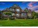 Stunning home with stone and siding exterior, showcasing lush landscaping and mature trees at 6250 Moinear Ln, Chapel Hill, NC 27514
