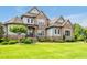 Inviting stone home features a professionally landscaped front yard and mature trees at 6250 Moinear Ln, Chapel Hill, NC 27514