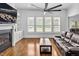 Bright living room with fireplace, TV, built-ins, plantation shutters and hardwood floors at 6250 Moinear Ln, Chapel Hill, NC 27514