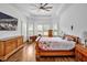 Spacious bedroom with tray ceiling, hardwood floors, sitting area and shuttered windows at 6250 Moinear Ln, Chapel Hill, NC 27514