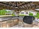 Outdoor kitchen with stone countertops, a built-in grill, and ample space for cooking and entertaining at 6250 Moinear Ln, Chapel Hill, NC 27514