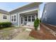 Quaint backyard porch entrance, adjacent to a narrow rock garden, creates a cozy setting at 6313 Kayton St, Raleigh, NC 27616