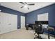 Bedroom features blue walls, white trim, carpet, a ceiling fan and a desk and chair at 6313 Kayton St, Raleigh, NC 27616