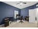 Bedroom features blue walls, white trim, carpet, a ceiling fan and a desk and chair at 6313 Kayton St, Raleigh, NC 27616