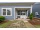 Charming covered front porch with white columns and brick trim, perfect for relaxing outdoors at 6313 Kayton St, Raleigh, NC 27616