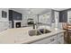 A well-lit kitchen island featuring stainless steel appliances, an island sink, and an open-concept design at 6313 Kayton St, Raleigh, NC 27616