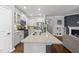 Open-concept kitchen with a large island, stainless steel appliances, and seamless access to the living room at 6313 Kayton St, Raleigh, NC 27616