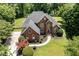Stunning aerial view of a traditional brick home with lush landscaping, a circular driveway, and a private backyard oasis at 6553 Vintage Ridge Ln, Fuquay Varina, NC 27526