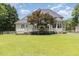 Large backyard features green grass, a deck with stairs and a mature tree for shade at 6553 Vintage Ridge Ln, Fuquay Varina, NC 27526