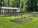 Spacious backyard featuring a chicken coop, gardening equipment, and lush greenery, ideal for outdoor activities at 6553 Vintage Ridge Ln, Fuquay Varina, NC 27526