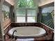 Relaxing bathroom showcasing a large soaking tub beneath a window with decorative walls at 6553 Vintage Ridge Ln, Fuquay Varina, NC 27526