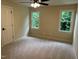 Bright bedroom featuring neutral carpet, two windows offering natural light, and a ceiling fan for added comfort at 6553 Vintage Ridge Ln, Fuquay Varina, NC 27526