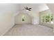 Bright bedroom featuring neutral carpet, ceiling fan, and large window at 6553 Vintage Ridge Ln, Fuquay Varina, NC 27526