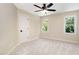 This carpeted bedroom has a ceiling fan, a door and two windows for natural light at 6553 Vintage Ridge Ln, Fuquay Varina, NC 27526