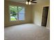 Bright bedroom with plush carpeting, a window overlooking the yard, and an entrance door at 6553 Vintage Ridge Ln, Fuquay Varina, NC 27526