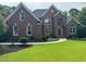 Charming brick two-story home with a manicured lawn and a walkway leading to the front door at 6553 Vintage Ridge Ln, Fuquay Varina, NC 27526