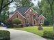 Beautiful brick two-story home with well-manicured landscaping, mature trees, and a curved driveway at 6553 Vintage Ridge Ln, Fuquay Varina, NC 27526