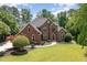 Stunning brick home featuring mature landscaping, a well-manicured lawn, and a classic architectural design at 6553 Vintage Ridge Ln, Fuquay Varina, NC 27526
