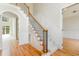 Elegant foyer featuring hardwood floors, carpeted stairs with wood and iron railings, and white wainscoting at 6553 Vintage Ridge Ln, Fuquay Varina, NC 27526