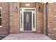 Elegant front door with decorative glass, sidelights, and outdoor lanterns, framed by brick at 6553 Vintage Ridge Ln, Fuquay Varina, NC 27526