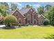 Beautifully designed brick home showcasing a lush green lawn and a professionally landscaped yard at 6553 Vintage Ridge Ln, Fuquay Varina, NC 27526