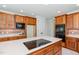 Well-appointed kitchen with a large island, cooktop, and modern appliances for comfortable cooking at 6553 Vintage Ridge Ln, Fuquay Varina, NC 27526