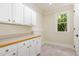 Well-lit laundry room featuring ample cabinetry, counter space, and natural light at 6553 Vintage Ridge Ln, Fuquay Varina, NC 27526