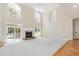 Bright living room featuring tall windows, fireplace, and access to an outdoor patio at 6553 Vintage Ridge Ln, Fuquay Varina, NC 27526