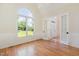 Bright living room featuring hardwood floors, wainscoting, and a beautiful arch window at 6553 Vintage Ridge Ln, Fuquay Varina, NC 27526