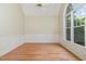 Spacious living room with hardwood floors, wainscoting, a ceiling fan, and large windows at 6553 Vintage Ridge Ln, Fuquay Varina, NC 27526
