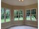 Bright living room featuring large windows with views of the landscaped backyard and natural light at 6553 Vintage Ridge Ln, Fuquay Varina, NC 27526