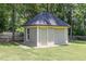 Charming outbuilding with light-green siding and a dark shingle roof, nestled among the trees with a sliding door at 6553 Vintage Ridge Ln, Fuquay Varina, NC 27526