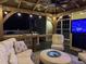 Relaxing covered patio with seating, outdoor grill, and entertainment setup offering a luxurious outdoor experience at 6553 Vintage Ridge Ln, Fuquay Varina, NC 27526